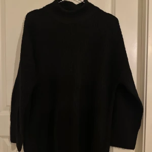 Svart stickad polotröja från ONLY - Mysig svart stickad polotröja från ONLY i storlek M. Tröjan har en hög krage, lång ärm och en loose fit som ger en chill vibe. Perfekt för lager-på-lager under kalla dagar. Enkel att matcha med jeans eller kjol.