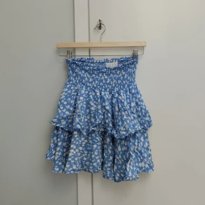 Snygg blåvit volangkjol! - En blåvit volangkjol från märket Samsa collection i storlek XS. Kjolen har smock längst upp vid midjan vilket gör att kjolen passar både XS och S! Använd några gånger men inga tecken på slitage, säljer då den inte kommer till användning. Köparen står för frakten och priset kan såklart diskuteras!🥳⭐