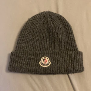 Moncler Mössa - Säljer denna gråa Moncler mössa för endast 499kr! Kom dm för frågor, pris kan diskuteras vid snabb affär.