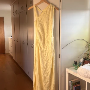 Ljusgul långklänning från Peppermayo - Säljer en snygg ljusgul långklänning från Peppermayo med oneshoulder-design och slits på sidan. Klänningen har en slim passform och är tillverkad i mjukt bomullsmaterial, den är bara använd 1 gång, då jag hade bal!!! 