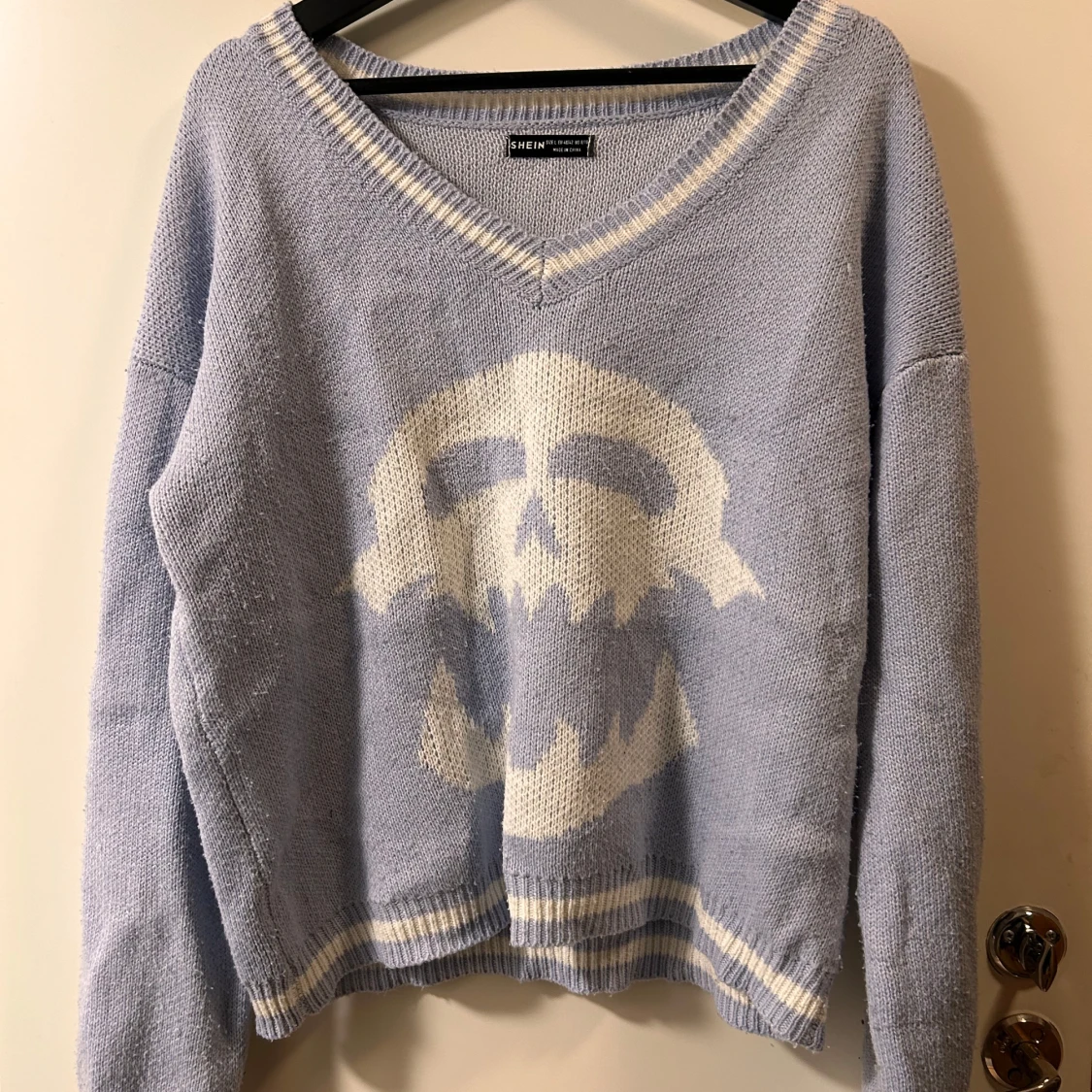 Ljuslila stickad tröja med döskalle