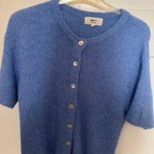Blå ribbstickad kofta från Gina Tricot - Supersöt blå ribbstickad kofta från Gina Tricot i ullblandning. Kortärmad modell med rund hals och knappar framtill. 