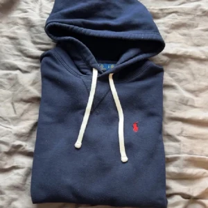 Marinblå Ralph lauren hoodie - Marinblå Ralph lauren hoodie size M | 9/10 skick defekten är att den är lite missfärgad allmänt men knappt så det syns annars i bra skick!