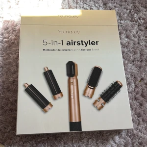 Youniquely 5-in-1 airstyler - Multifunktionell airstyler med fem utbytbara tillbehör i svart och roséguld. Perfekt för att skapa olika hårstilar med borstar och locktillbehör. Ergonomisk design och enkel att använda för styling hemma. Pris kan diskuteras vid snabb affär 