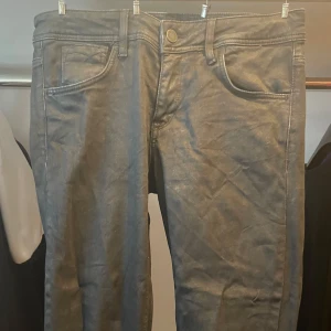 Glittriga svarta slim jeans från Mexx W29 - Snygga svarta jeans från Mexx i slim fit-modell. Klassisk femficksdesign och diskret tvättad look. Jeansen är lätt glittriga för en extra detalj till din look. Detta visas på bild 2 och 3.  Perfekta för dig som gillar en smalare passform och stilrena kläder.