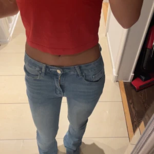 Ljusblå jeans från shein - Säljer ett par ljusblå jeans med snygga broderier och nitar på bakfickan. Jeansen har låg midja, klassisk femficksmodell och dragkedja. Materialet är mjukt denim och passformen är slim med raka ben. Perfekta för dig som gillar detaljer och en avslappnad stil.