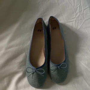 Blå ballerinaskor i jeans  - Snygga blå ballerinaskor från H&M i jeansmaterial med rund tå och platt sula. 💗i är storlek 35 