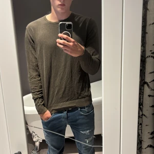 Grön/brun Jack and Jones tröja - Säljer en grön Jack and Jones tröja som sitter riktigt bra, bara lite tajt på mig eftersom att jag har växt ur den men den passar perfekt för större M och lite mindre L.  Ny pris 599 kr
