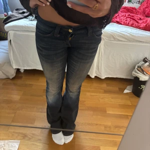 Bootcut jeans  cheap Monday  - Snygga bootcut jeans i mörkblå tvätt med slitningar framtill. Klassisk femficksmodell och låg midja, storlek 26/32. 💕