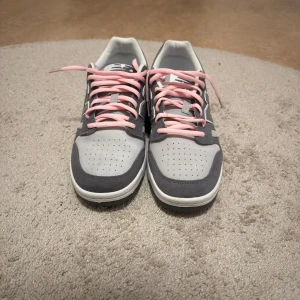 Custom New Balance BB480  - Säljer ett par Custom New Balance BB480LEC sneakers i grått med ljusgrå mesh och mockadetaljer. De har rosa snören som ger en snygg kontrast och klassisk N-logga på sidan. Platt sula och rund tå för skön passform. Perfekt för dig som gillar stilrena och sportiga skor. 