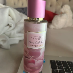 Victoria's Secret Pure Seduction Daydream - Fräsch och söt body mist från Victoria's Secret i doften Pure Seduction Daydream. Flaskan är rosa med molnigt mönster och har detaljer i guld. Doften har inslag av plommonsocker och vit mocka för en mjuk och drömmig känsla. OANVÄND