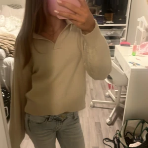 Beige pikétröja med krage - Säljer en stilren beige pikétröja med klassisk krage och lång ärm. Tröjan har en avslappnad passform och är gjord i ett mjukt material som känns skönt mot huden. Perfekt för dig som gillar en clean och enkel look.