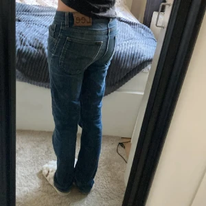 Blå Lee jeans straight fit - Säljer ett par klassiska blå jeans från Lee med raka ben och normal passform. Jeansen har fem fickor, snygga kontrastsömmar och Lee-logga på bakfickan. Tillverkade i slitstarkt denimtyg som sitter skönt på kroppen.