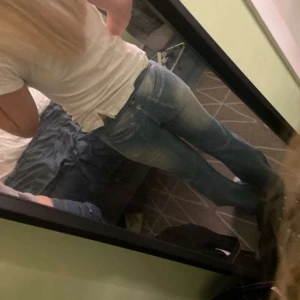 Blå bootcut jeans mid waist - Säljer ett par blå jeans med snyggt slitna detaljer och bootcut-ben. Perfekta för dig som gillar en avslappnad och trendig look. Materialet är jeans och passformen är normal. Dom är avklippta längst ner.