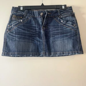 Kort jeanskjol med slitna detaljer! - Ascool jeanskjol med slitna detaljer! Köpt second hand men har aldrig använt själv. Säljer pga den är inte min stil längre💗 Storlek 27! Inga defekter men har som sagt en mer sliten look. Tveka inte att fråga ifall du har några frågor💕  Mått:🫶 Midja (tvärs över): 39  Längd: 28,5 (1 cm längre på baksidan)