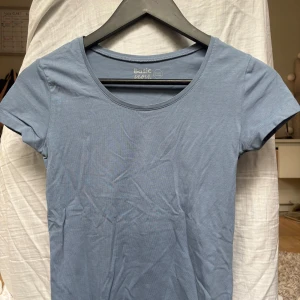Blå basic t-shirt  - Enkel och stilren lite dovblå t-shirt från Basic You i storlek Xs. Modellen är klassisk med rund halsringning och korta ärmar. Den är använd men inget som syns!! Kontakta om du har några funderingar!!❤️