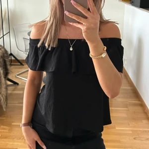 Svart offshoulder topp från Gina Tricot - Svart offshoulder topp från Gina Tricot med volangdetalj längs överdelen. Strl S men passar även XS. Sparsamt använd - Mycket bra skick. 