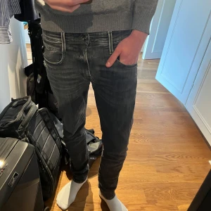 Replay grå slim jeans - Säljer ett par svart/grå slim fit jeans från Replay med lätt slitna detaljer. Modellen anbass. Storlek 29/32
