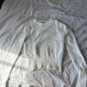 Vit fluffig stickad tröja från Zara - Säljer en supermjuk och fluffig vit stickad tröja från Zara. Tröjan har rund halsringning och långa ärmar och en figursydd mudd. Inte stickig💕