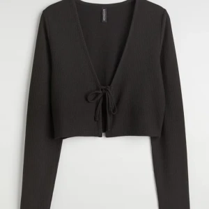 Svart croppad bolerotopp från H&M med prislapp  - Säljer denna svarta croppade ”koftan” från H&M aldrig använd med prislapp kvar då jag köpte fel storlek och aldrig hann lämna tillbaka. 🤍XXS