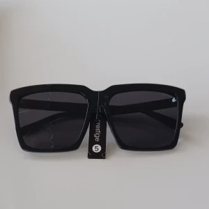 Svarta solglasögon med fyrkantiga bågar från Prestige - Stilrena svarta solglasögon från Prestige med stora, fyrkantiga bågar och mörka glas. Perfekta för dig som vill ha en modern och cool look. Svensk design.