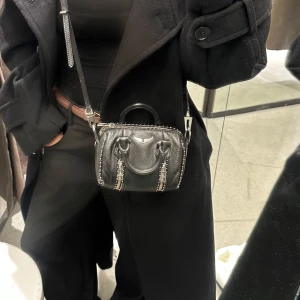 Svart axelväska från Zadig & Voltaire - Säljer en svart axelväska i skinn från Zadig & Voltaire med silverfärgade dragkedjedetaljer och ett litet handtag upptill i bra skick. Pris kan diskuteras 