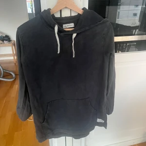 Svart hoodie från I dig denim - Säljer en svart hoodie från I dig denim med vit dragsko och magficka. Perfekt för en avslappnad stil och enkel att matcha med det mesta. Klassisk modell med långa ärmar och mjukt material. Den är i storlek 158/164 men sitter som en xs/s. 