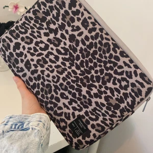 Leopardmönstrad datorväska från lager 157 - Säljer en snygg datorväska med leopardmönster från Denim Makers. Väskan har dragkedja och är perfekt för att skydda din laptop. Stilig och trendig accessoar för dig som vill sticka ut.