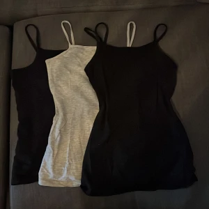 3-pack linnen med smala axelband - Säljer tre linnen med smala axelband, två i svart och ett i ljusgrått. Perfekta att bära som basplagg eller under tröjor. Mjukt och stretchigt material som sitter skönt mot kroppen.