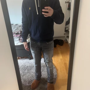 Mörkblå hoodie från Polo Ralph Lauren - Säljer en mörkblå hoodie från Polo Ralph Lauren med vit dragsko och klassisk gul logga på bröstet.  Storlek S 