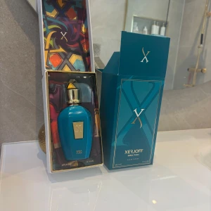 Xerjoff Erba Pura Eau de Parfum 100ml - Lyxig parfym från Xerjoff, Erba Pura, i en elegant blå flaska med gulddetaljer och tillhörande färgstark förpackning. Doften är känd för sina fruktiga och fräscha noter, perfekt för dig som vill sticka ut med en exklusiv signaturdoft. OBS: inget kvitto, ALDRIG ANDVÄND 