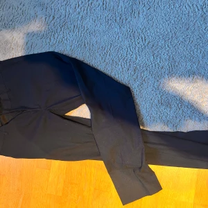 Svarta kostymbyxor från Bruun & Stengade - Snygga svarta kostymbyxor med material linne från Bruun & Stengade. Klassisk rak passform med pressveck och diskret knapp- och dragkedjestängning. Perfekta till mer uppklädda tillfällen eller när du vill känna dig extra stilig. Använd 1 gång hör av dig vid minsta fundering!