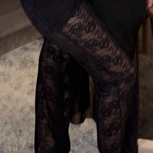 Svarta spetsbyxor med utsvängda ben - Säljer ett par svarta byxor i spets  och utsvängda ben. Byxorna är genomskinliga och har en elegant look, perfekta för att sticka ut.