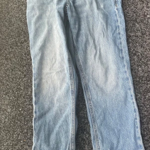 Ljusblåa jeans från Jack & Jones, Regular Clark Fit - Säljer ett par klassiska blå jeans från Jack & Jones, modell Regular Clark. Jeansen har en rak/straight passform, fem fickor och normal midja. Perfekta till vardags och lätta att matcha med olika stilar. Har använts ganska mycket men i fint skick. Säljes pga att jag växt ur dem.
