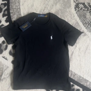 svart t shirt - En svart helt ny Ralph laurent t shirt. Har aldrig använt den. Tröjan är i storlek s men den är lite mindre i formen. Pris kan diskuteras