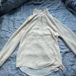 Blus med blomkrage  - En blus med resår på ärmarna och i nacken med en blomkrage