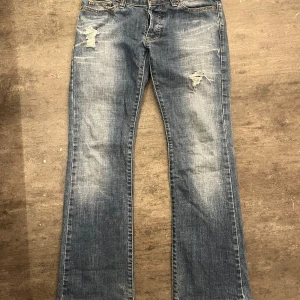 Blå bootcut jeans med slitningar - Superfina Lågmidjade jeans från replay. Tyvärr har dem två hål vid hälarna men annars bra skick. Midjemått: 38 cm, innerbenslängd: 78cm💟💟💟