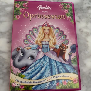Barbie som Öprinsessan DVD - Säljer filmen 'Barbie som Öprinsessan' på DVD. Omslaget är rosa med Barbie i en blå klänning, omgiven av djur och blommor. Filmen innehåller 9 originalsånger och är ett musikaliskt äventyr för hela familjen. Bra skick 
