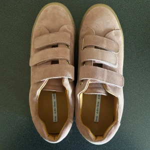 Rosa sneakers med kardborre - Säljer ett par coola ljusrosa sneakers från & Other Stories i mocka med kardborreband. Endast använda en gång. Dom är i storlek 39, men skulle säga att dom även passar en 40 då jag kan ha båda💕💕💕💕