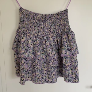 Lila blommig volangkjol - Kortkjol med fina blomdetaljer, använd max 5 gånger, superbra skick! 