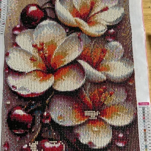 Diamond painting med blommotiv - Säljer en färdig diamond painting med stora vita och gula blommor samt röda detaljer. Tavlan har en rektangulär form och motivet är fyllt med små glittrande pärlor som ger en 3D-effekt. Perfekt som dekoration till hemmet.