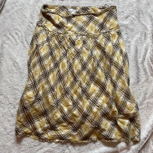 Rutig kjol från Day Birger et Mikkelsen - Säljer en somrig kjol från Day Birger et Mikkelsen i gult, beige och brunt rutigt mönster. Kjolen har en lätt A-linjeform och är tillverkad i ett tunt, mjukt material som ger ett avslappnat intryck💗