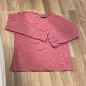 Rosa stickad tröja från Vero Moda - Mysig rosa stickad tröja från Vero Moda. Tröjan har en enkel design med rund halsringning och långa ärmar. Perfekt för att hålla sig varm under kyligare dagar. Snygg att styla till både jeans och kjol.