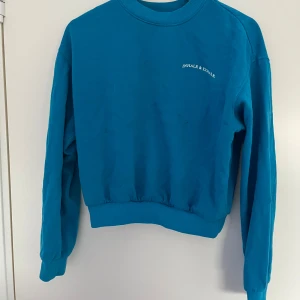 Blå sweatshirt med text - Säljer en blå sweatshirt med rund hals och tryckt text 'inhale and exhale’ den hr en liten fläck