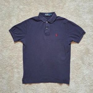 Marinblå Ralph Lauren Pike - Stl S - Hej säljer en snygg Ralph Lauren pike! Den är marinblå. Stl S. Fint skick men kan ha tappat lite färg från tvätten. Fortfarande skit snygg! 😮‍💨 Hör av dig om du har några frågor! 