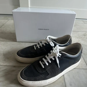 Common projects skor - Tjena! Lägger nu upp dessa as feta common projects sneakers i en snygg mörkgrå/svart färg! Skorna är i ett väldigt bra skick och utan defekter, min bedömning 9/10! Vid köp medföljer box, påse, extra snören och digitalt kvitto! Skorna är köpa från care of Carl för ungefär 3 månader sen och nypriset ligger på 5000! Skriv privat vid frågor eller funderingar!