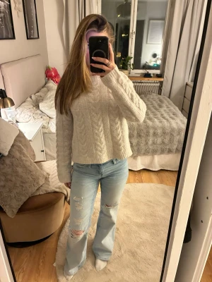 Ljusblå slitna jeans med vida ben - Säljer ett par ljusblå jeans med vida ben och slitningar på låren och knäna. Jeansen har klassisk femficksdesign och hög midja. Materialet är denim och de har en avslappnad passform som ger en cool och trendig look.