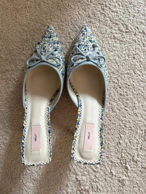 Blommiga pumps med rosett  - Säljer ett par söta klackar från Nelly. Dom är super bekväma! 