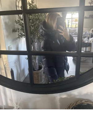 Marinblå pufferjacka från Ralph Lauren - Snygg marinblå pufferjacka från Ralph Lauren med hög krage och vadderad design. Jackan har en glansig finish och klassisk pufferlook, perfekt för kalla dagar. Ikonisk logga på bröstet och dragkedja framtill. Oversized känsla och riktigt varm.