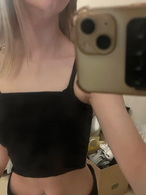 Svart croppad linnetopp - Säljer en svart croppad linnetopp med smala axelband. Toppen har en enkel och stilren design som passar perfekt till jeans eller kjol. Materialet känns mjukt och följsamt mot huden.